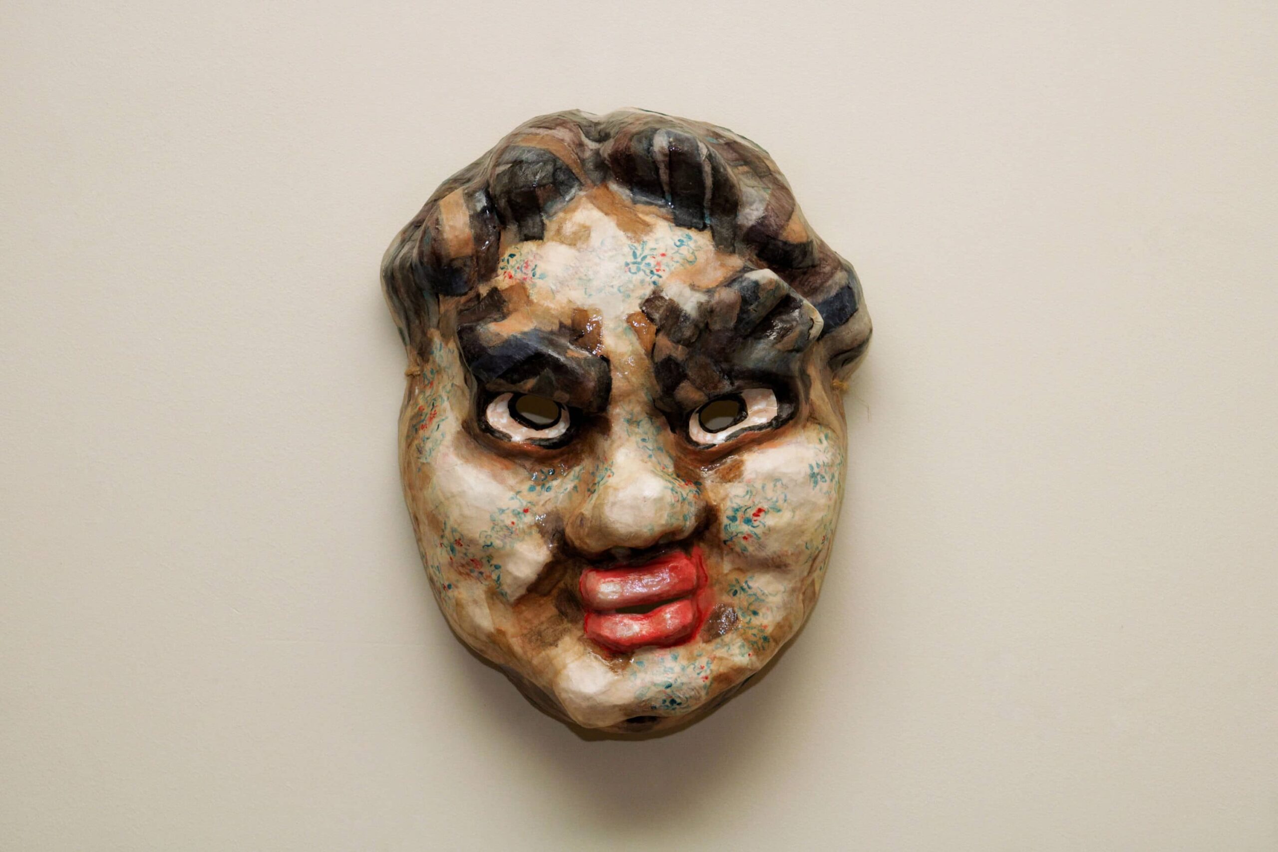 wall-mounted mask with disdainful expression, combining yakuza iconography with surreal cartoon exaggeration