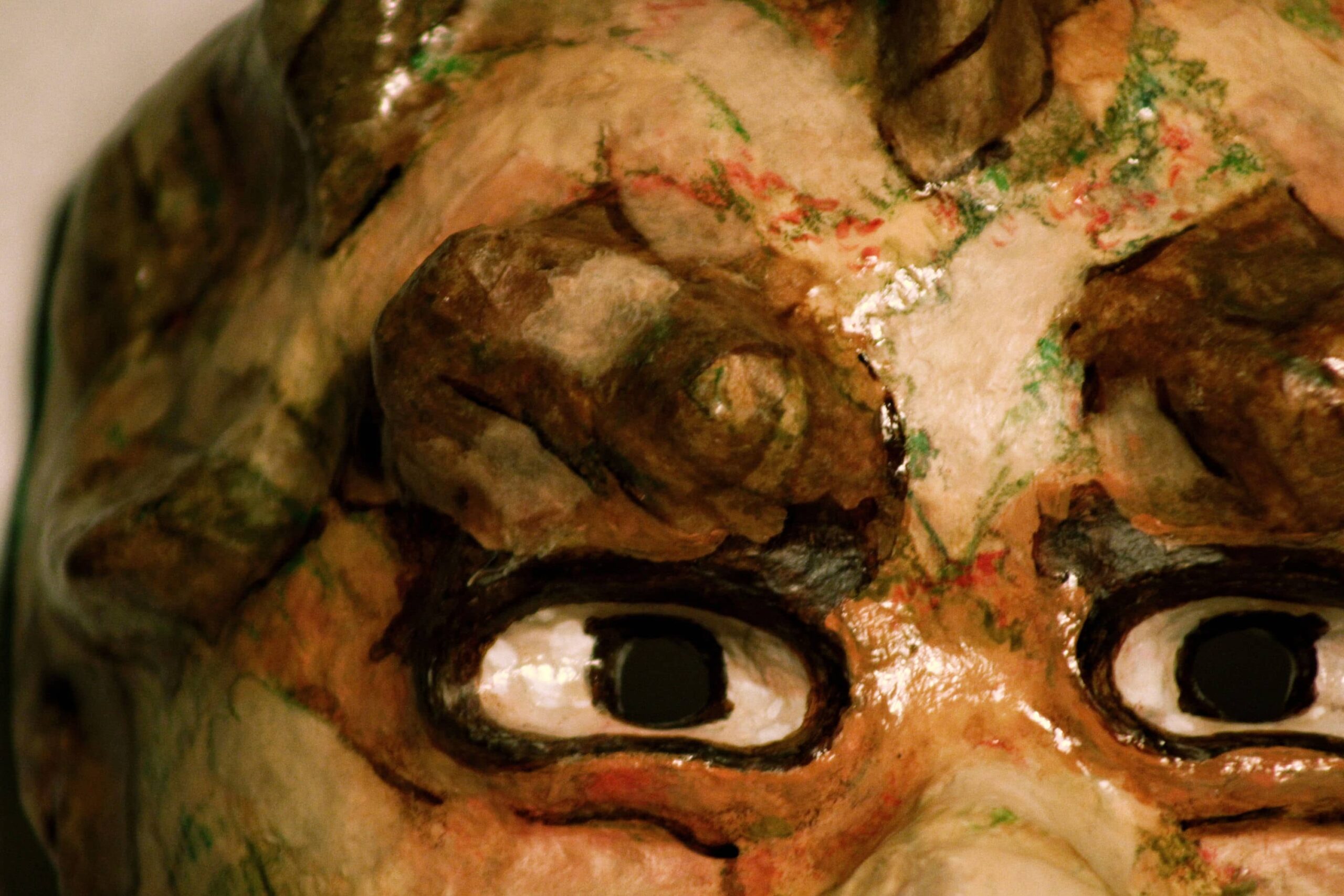 zoomed-in view of painted eyes under heavy brows, layered with scratchy colored marks