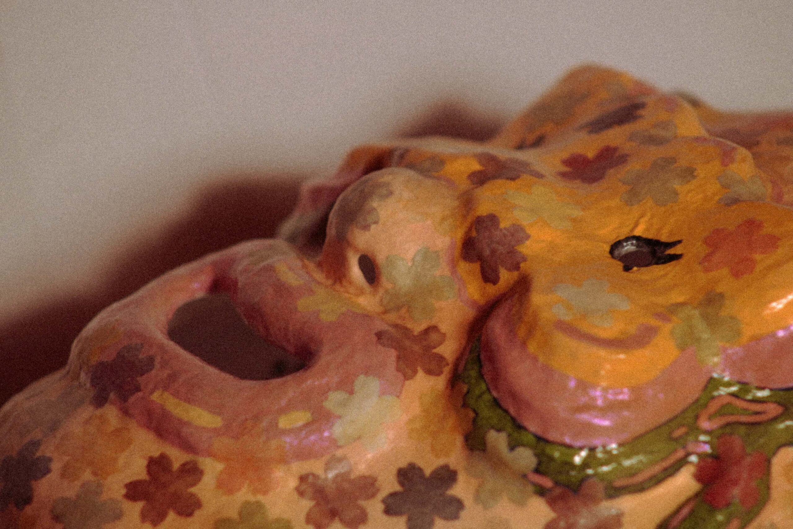 side profile of a contemporary handmade mask with protruding nose and multicolored floral design