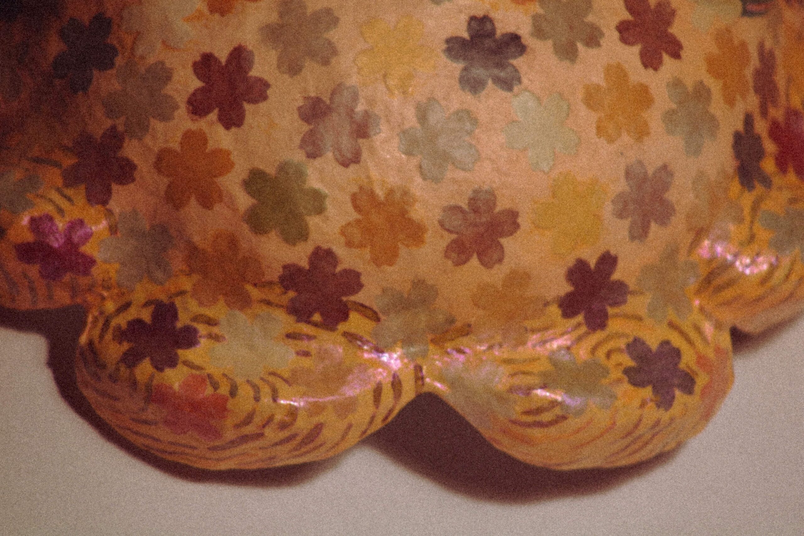 top view of a handmade floral mask fully covered in small colorful painted flowers with glossy finish