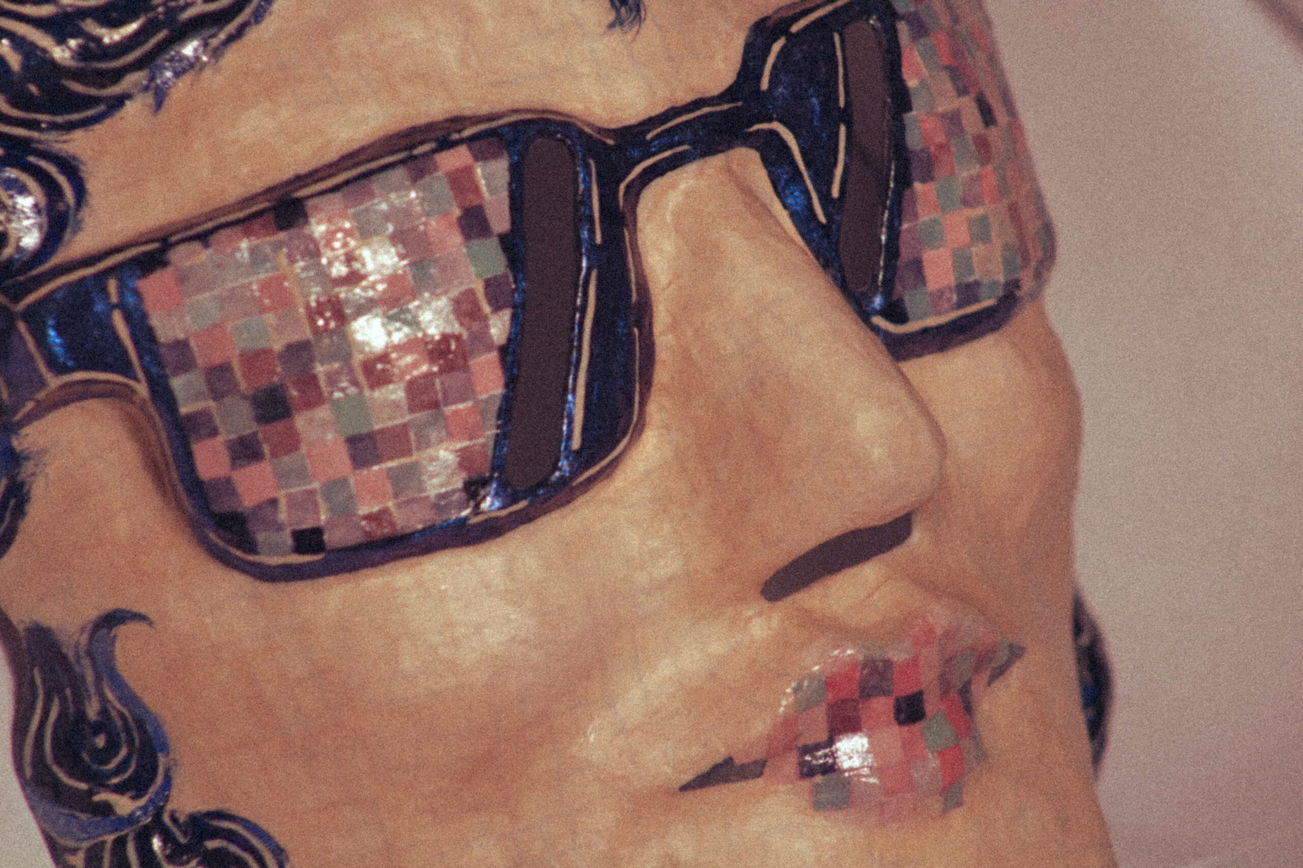 close-up of a contemporary handmade mask with mosaic sunglasses, defined nose and glossy painted finish