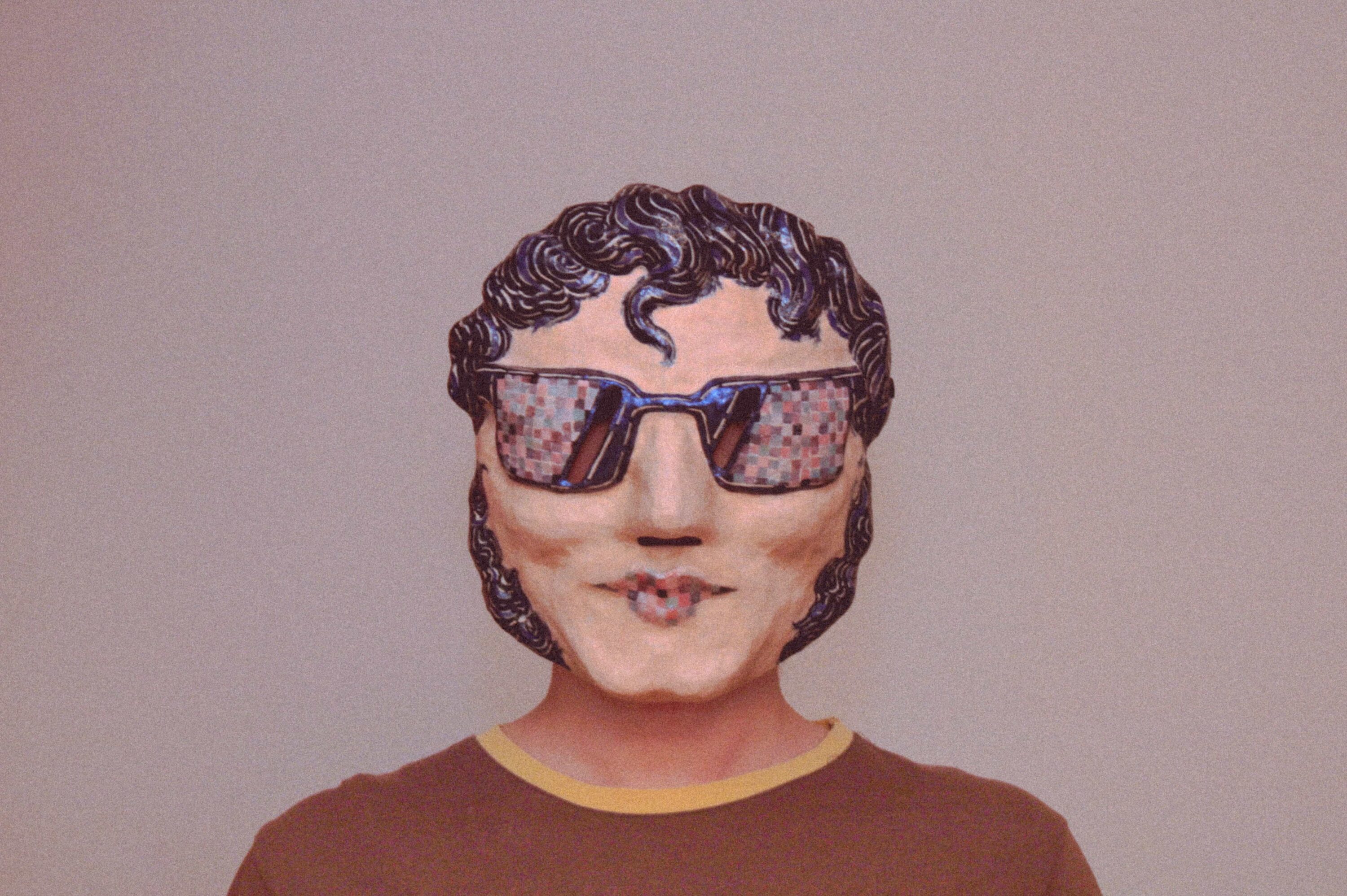 person wearing a handmade sculptural mask with sunglasses, showing how the mask fits on the face