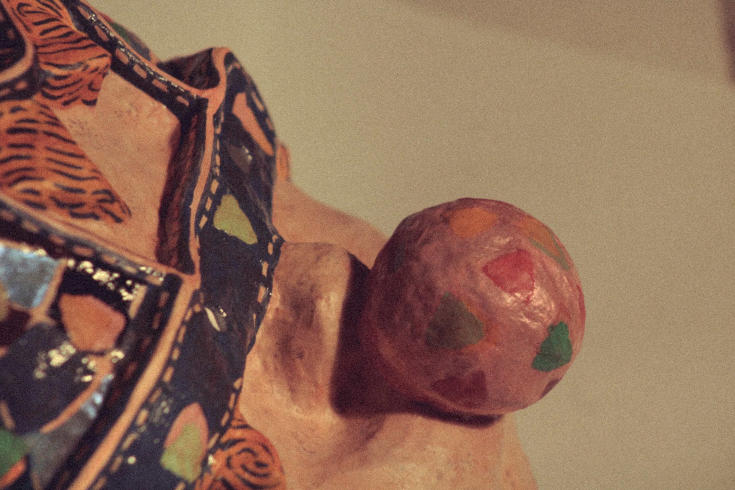 angled close-up of a handmade mask highlighting protruding bubblegum balloon and painted surface details
